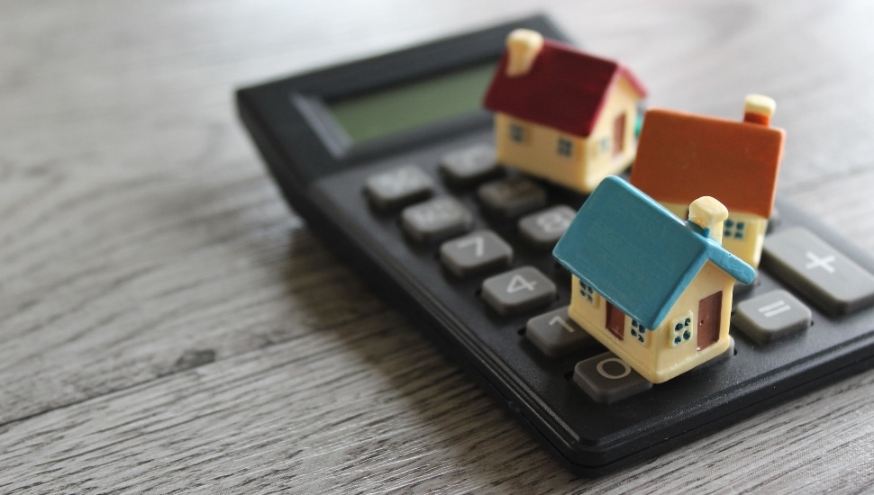 Toy houses sitting on a calculator