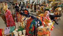 woman sorting through the racks of a Reclectic store.