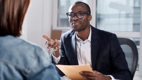 person at office talking at desk with colleague salary negotiation strategies