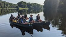 Philadelphia teachers sitting in canoes on the Delaware River.