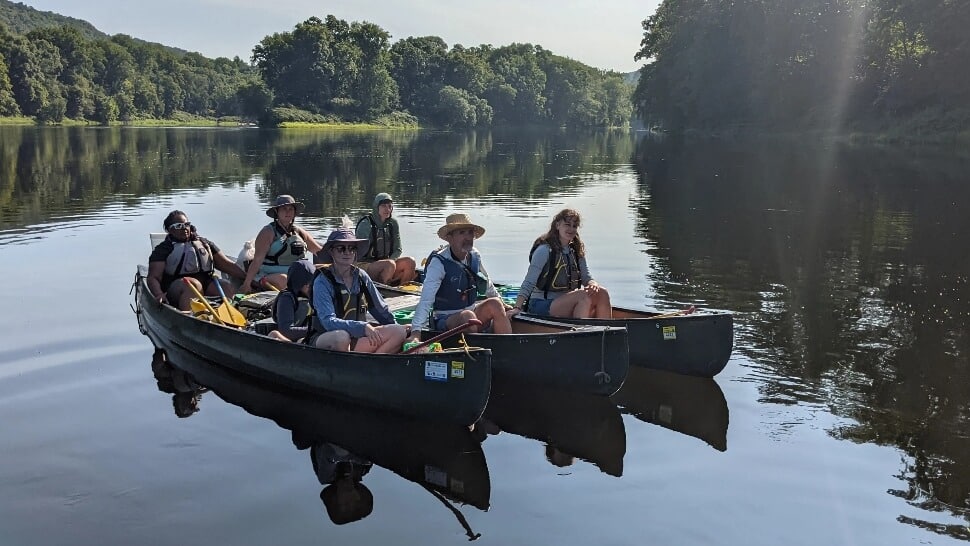 Philadelphia teachers sitting in canoes on the Delaware River.