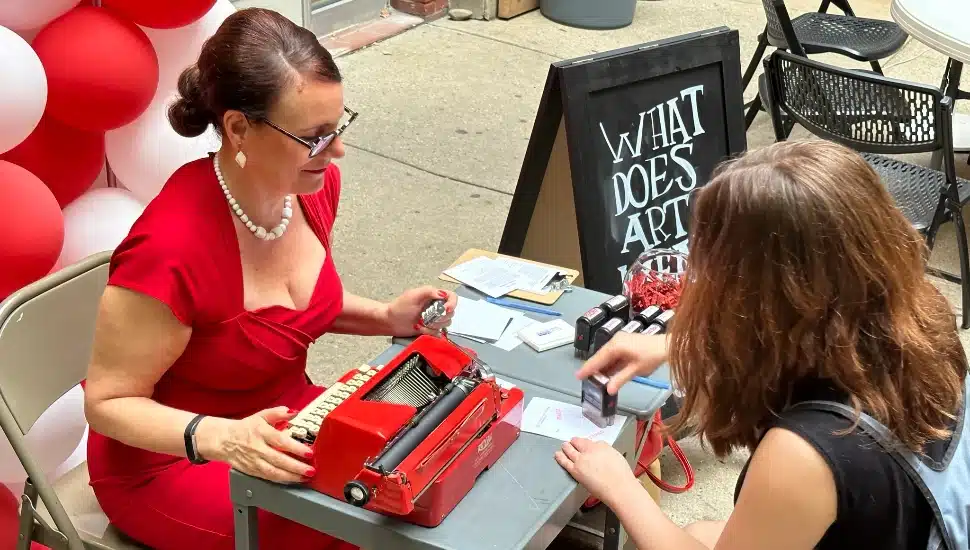 Sheryl Oring sitting at her typewriter in Center City