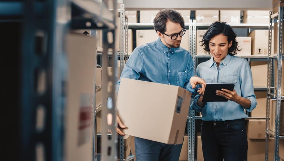 Female Inventory Manager Shows Digital Tablet Information to a Worker Holding Cardboard Box, a distribution manager is one of the highest paying jobs in Philadelphia