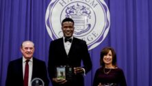 From left: Denis C.Boyle, Augustine Okosun ’07, and Karen Naylor ’92 standing in front of Harcum College logo