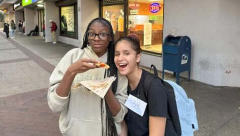 Philly high schoolers Zakiyah Jacobs and Isis’le Bermudez try out a sample of Wawa's pizza.