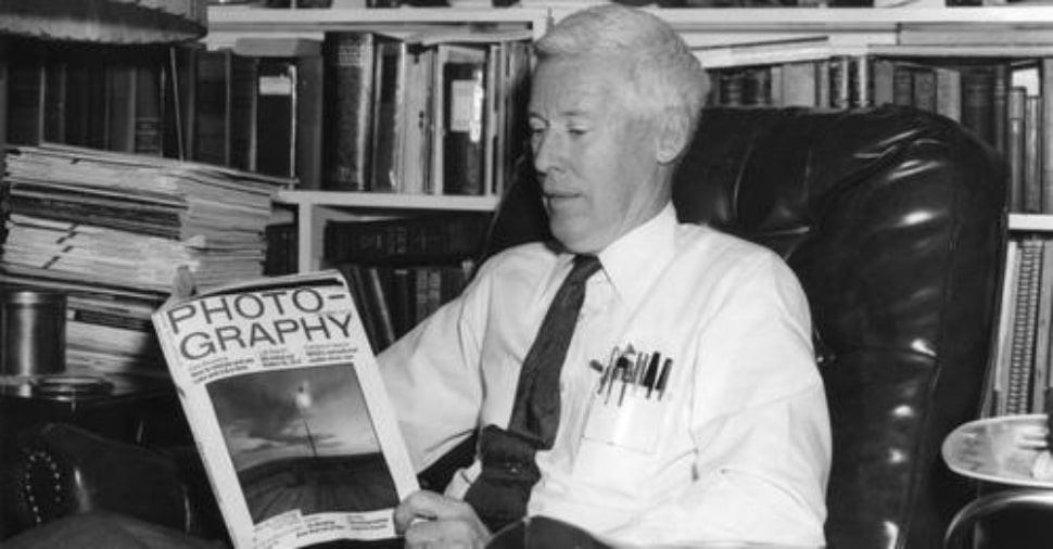 Photographer Robert S. Halvey reading a book on photography.