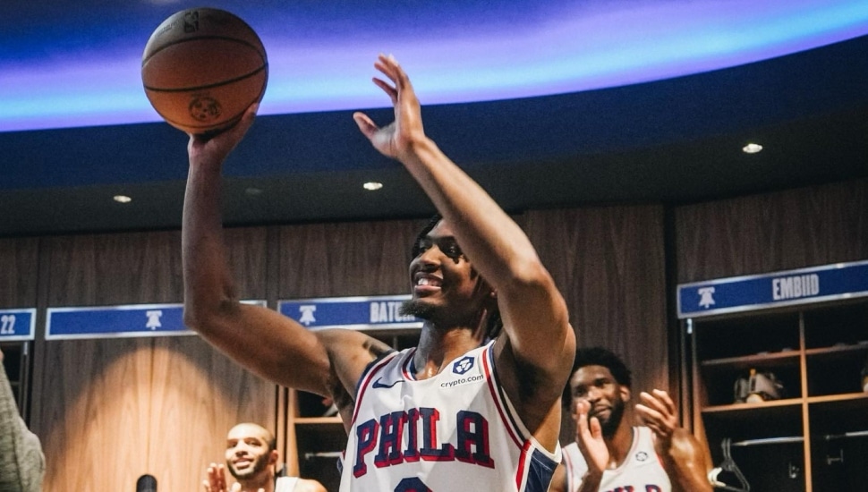 Tyrese Maxey holding game ball in the Philadelphia 76ers locker room after 50-point performance.