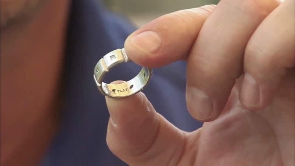 Man holds a gold wedding band in his hands