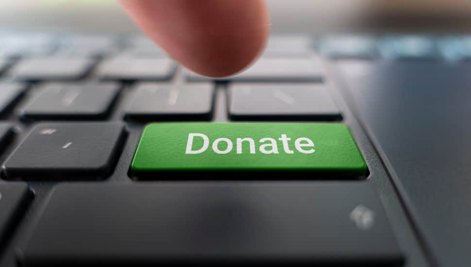 person pressing green donate button