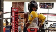 Zakariyah Chapman with boxing gloves and head gear.