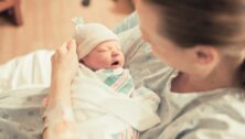 A mother holding a newborn in her arms.