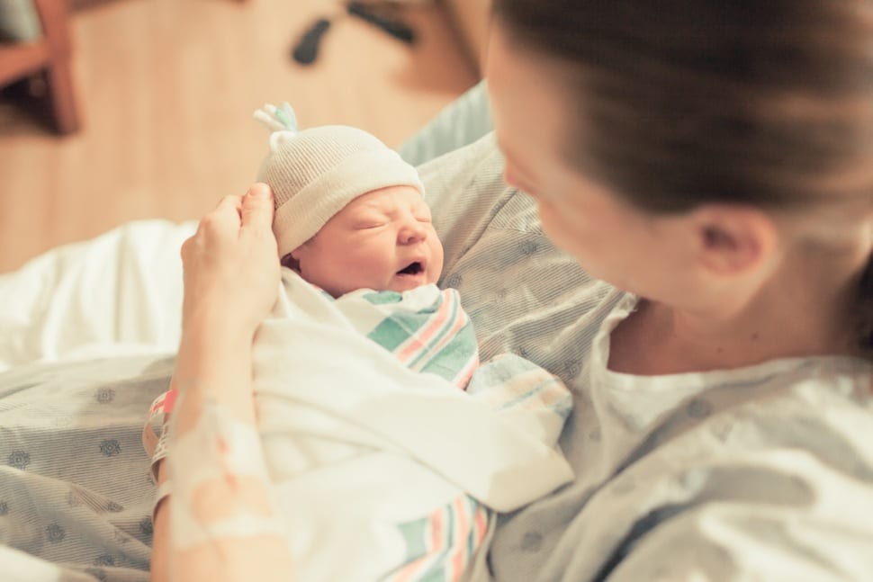 A mother holding a newborn in her arms.