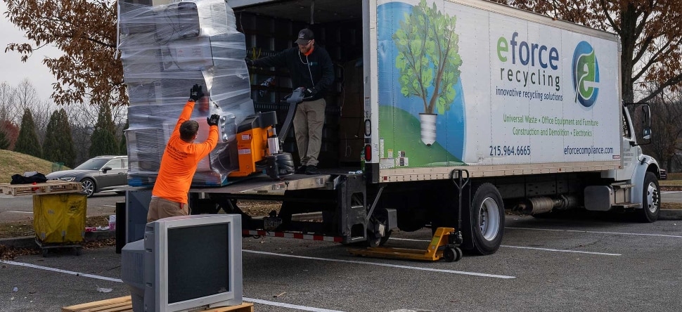 Workers placing materials in the back of a truck