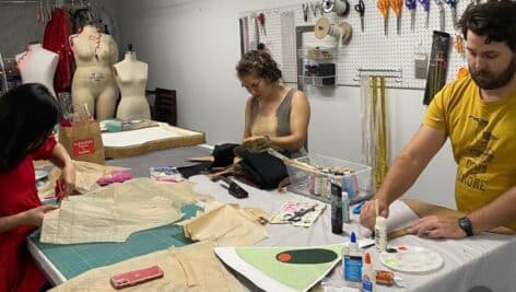 Individuals sewing, cutting, designing