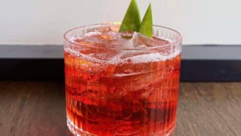 Drink made with pineapple mezcal, coconut Campari, and vermouth.