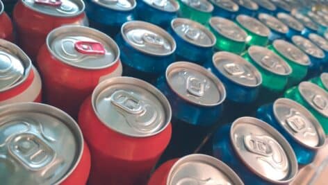 Rows of colorful metal cans with soda drink in shop stock photo