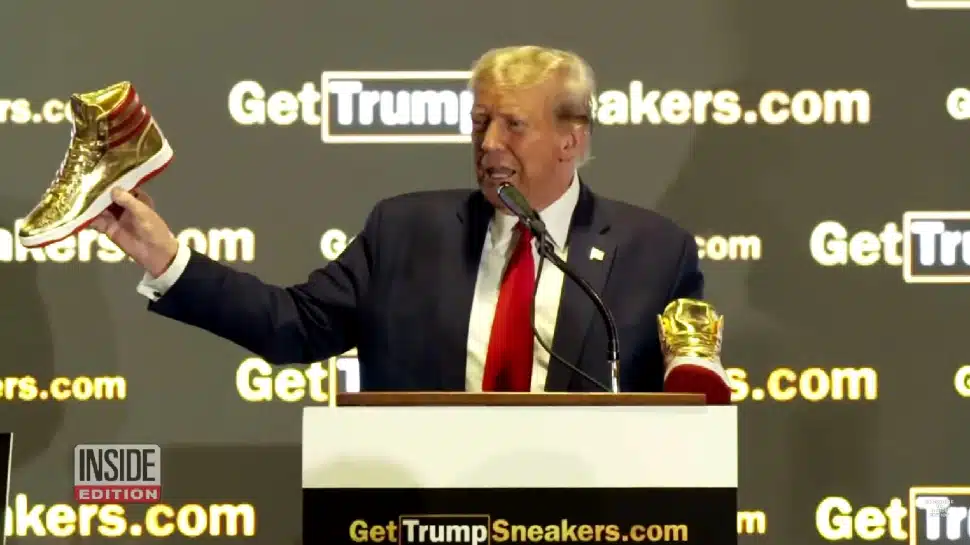 Donald Trump holding up his new sneaker.