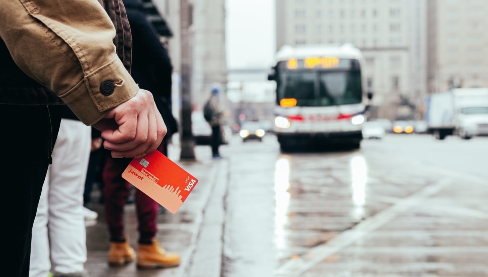 Man holding a new Jawnt pass waits for the bus