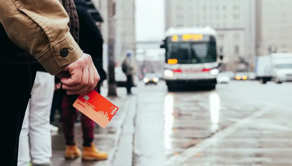 Man holding a new Jawnt pass waits for the bus