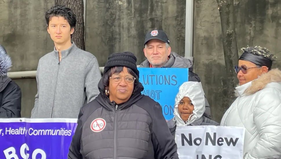Neumann University political science professor Dr. Robert McMonagle at a protest with a sign and behind and to the right of Zulene Mayfield, chairperson of Chester Residents Concerned for Quality Living.