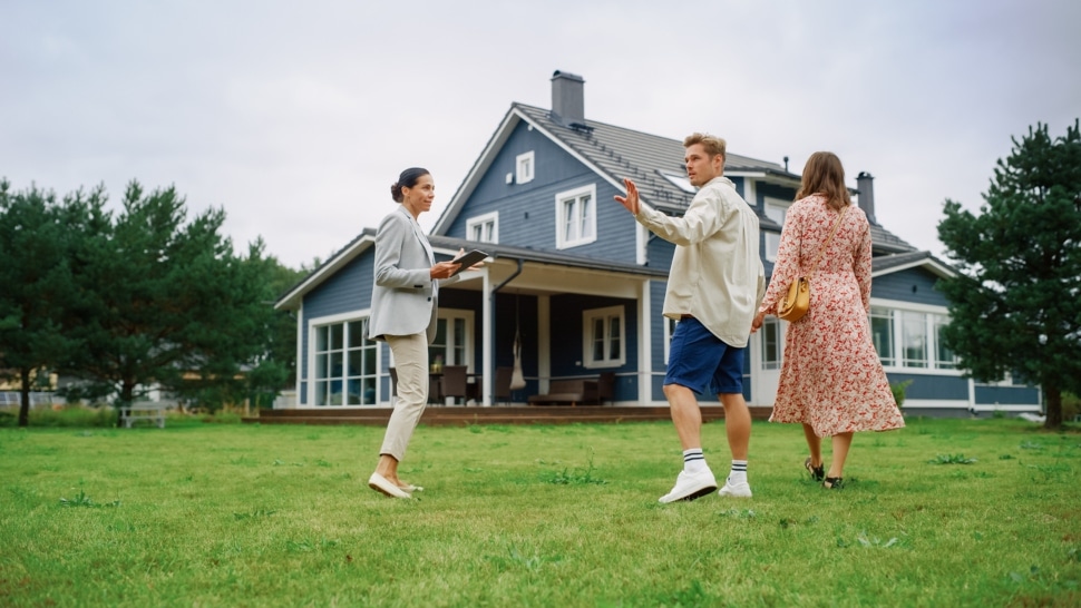 Young Couple Visiting a Potential New Home Property with Professional Real Estate Agent