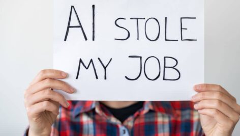 Man hold a sign saying AI stole his job.