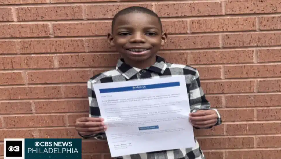 Cree Carroll holding up his Mensa acceptance letter