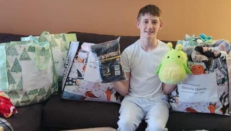 Declan Cassidy sitting in the home surrounded by items to be donated.