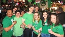 People wearing green inside a bar for St. Patrick's Day.