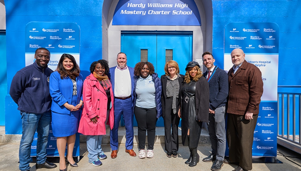 Individuals standing outside Hardy Williams Academy Mastery Charter School in Southwest Philadelphia.