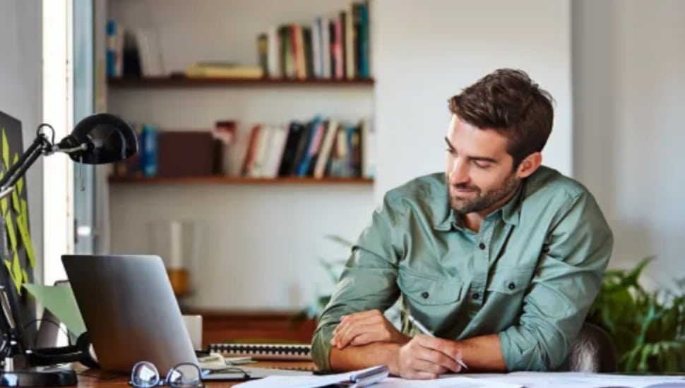 Man looking over finances on laptop.