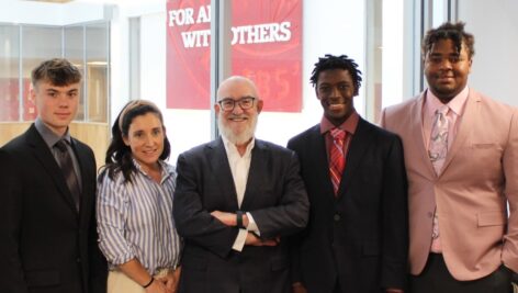 Nick and Meg Howley standing with St. Joe's Prep students