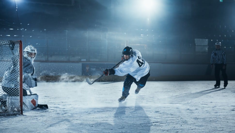 A goalie is on the defensive during an ice hockey game in an ice rink.