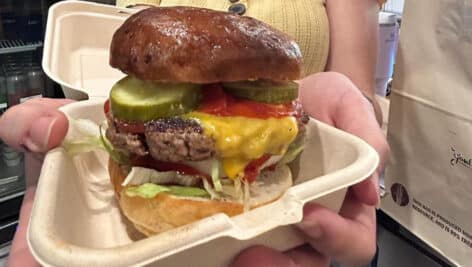 A woman holding a burger from Gouldsburgers.