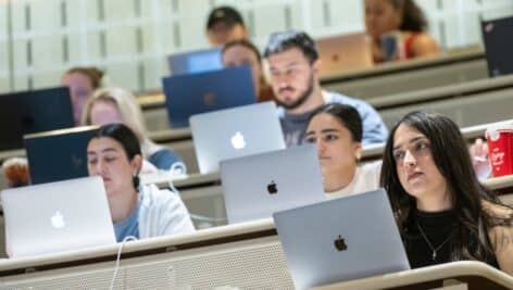 Students in class in front of laptop computers.