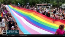 People holding the Pride flag during 2024 Pride event.