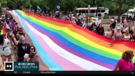 People holding the Pride flag during 2024 Pride event.