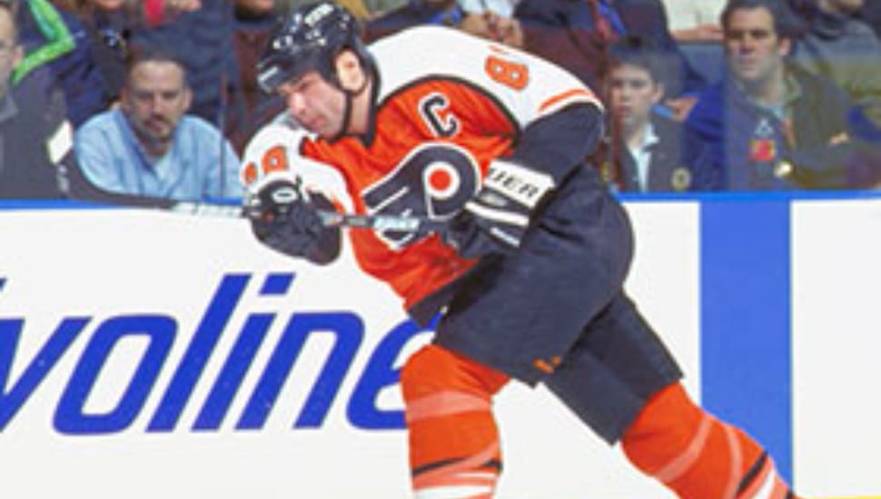 Eric Lindros on the ice shooting the puck.