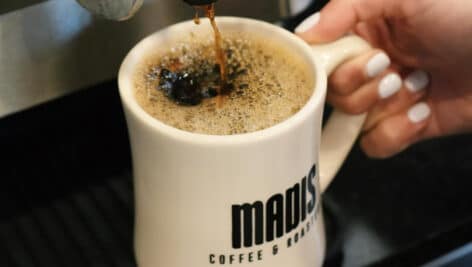 A Madis Coffee mug with coffee in it.