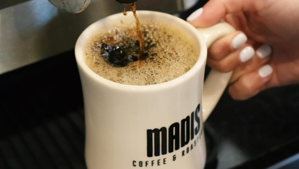 A Madis Coffee mug with coffee in it.