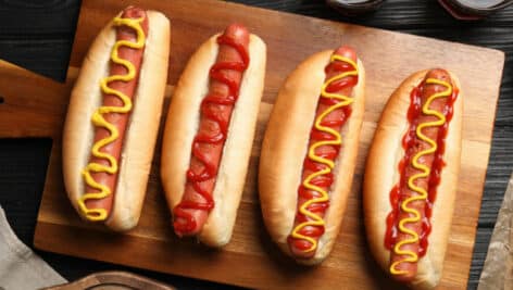 Four hotdogs; two with ketchup and two with mustard.