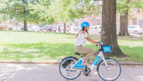 A young woman riding an Indego bike.