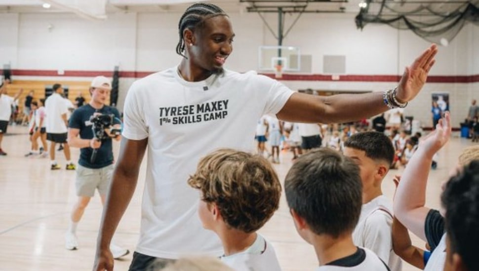 Tyrese Maxey high-fiving youth.