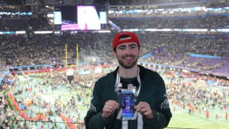 Brian Thomas holds pass at Philadelphia sports game.