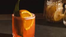 A drink with an orange wedge in it.