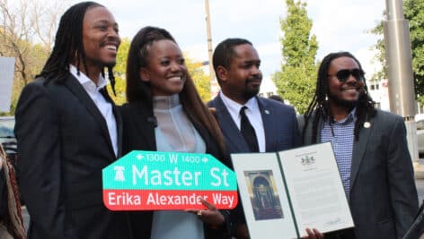 Erika Alexander poses with "Erika Alexander Way" sign, alongside Malcolm Kenyatta, Sharif Street, and Jeffrey Young.