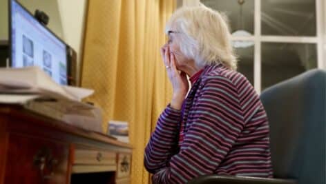 concerned/worried elderly lady at her laptop.