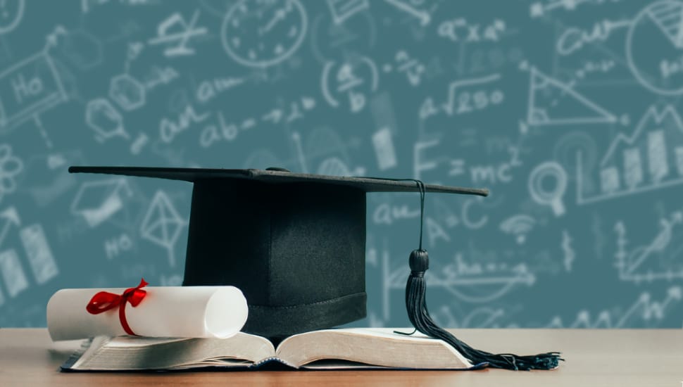 A graduation cap, diploma, and book.