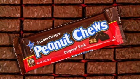 A wrapped Peanut Chews bar on top of several unwrapped bars.