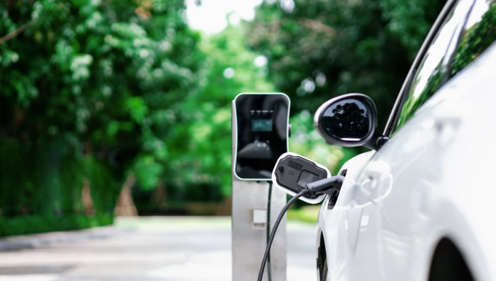 Focus closeup EV car and charger with blurred background.